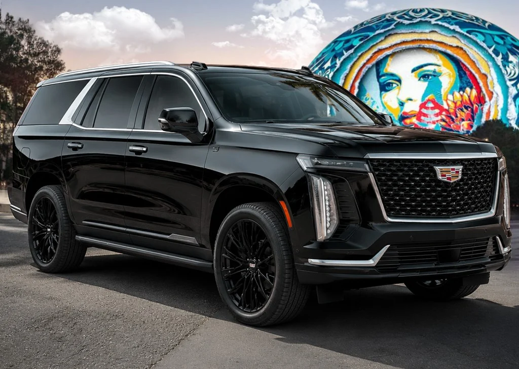 Black Cadillac Escalade parked outdoors beside a colorful Las Vegas mural