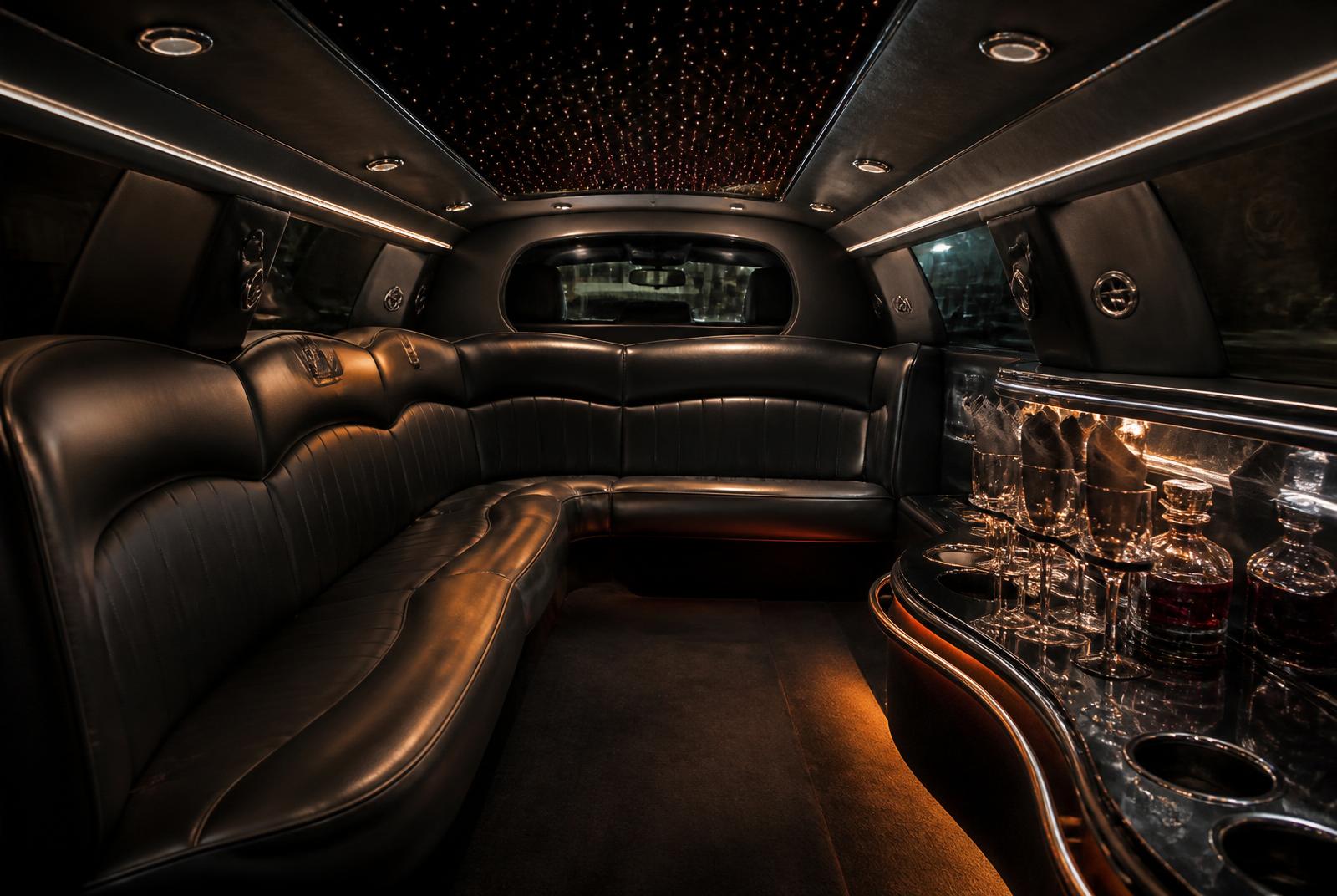 Illuminated wraparound leather seating inside the black Lincoln MKT limousine